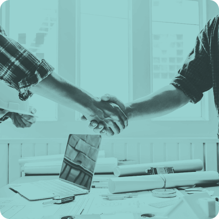 Closeup of a handshake above a workstation